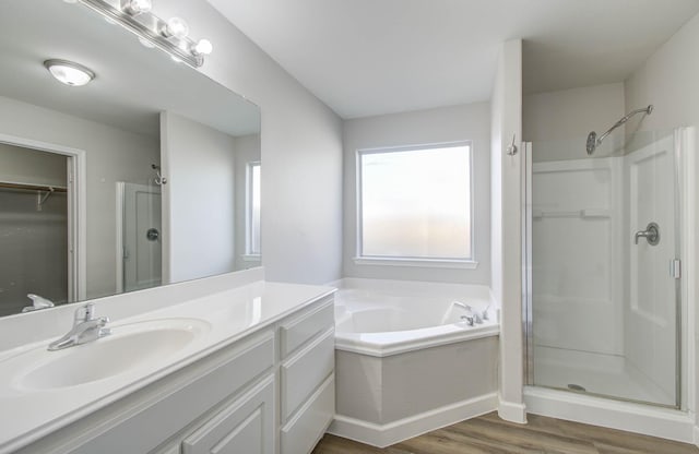 bathroom featuring vanity, wood-type flooring, and shower with separate bathtub