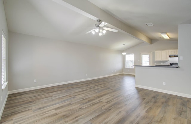 unfurnished living room featuring hardwood / wood-style flooring, vaulted ceiling with beams, and ceiling fan