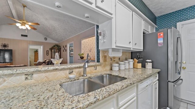 kitchen featuring white cabinetry, dishwasher, ceiling fan, sink, and vaulted ceiling