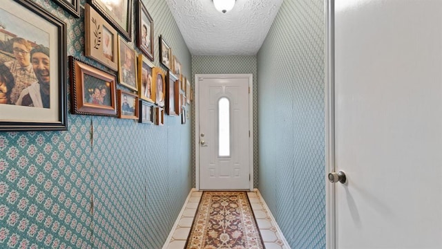 doorway to outside featuring a textured ceiling and tile patterned floors