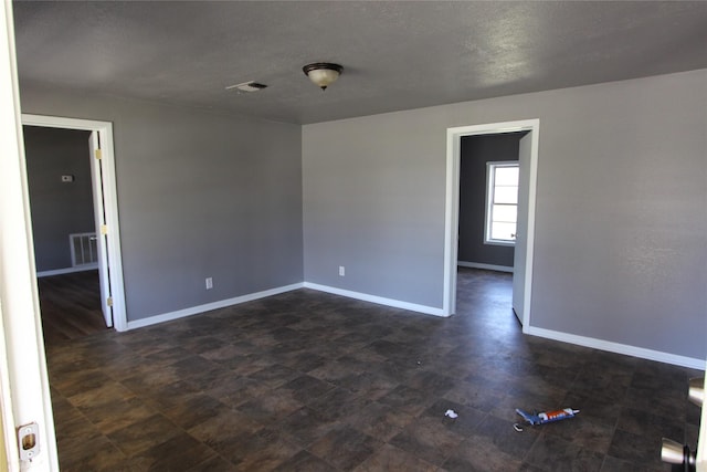 unfurnished room featuring a textured ceiling