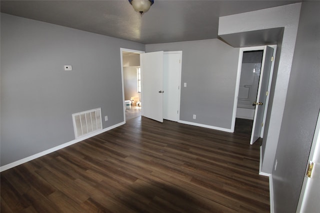 unfurnished bedroom with dark hardwood / wood-style flooring