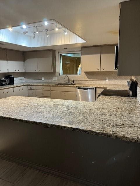 kitchen featuring dishwasher, stove, white cabinetry, and sink