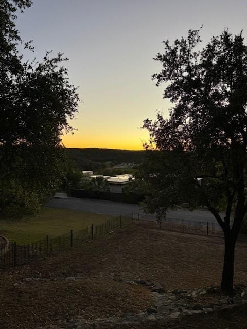 yard at dusk featuring a rural view