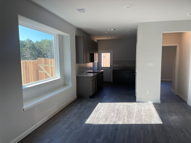 kitchen with tasteful backsplash, sink, and dark wood-type flooring