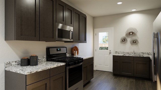 kitchen featuring sink, dark hardwood / wood-style floors, light stone countertops, dark brown cabinetry, and stainless steel appliances