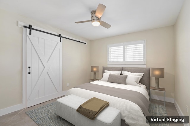 bedroom with ceiling fan and a barn door