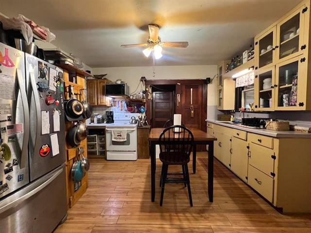 kitchen with white range with electric cooktop, ceiling fan, stainless steel fridge, and light hardwood / wood-style floors