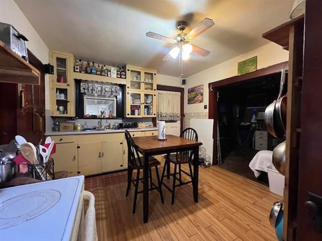 dining space featuring ceiling fan, light wood-type flooring, and sink