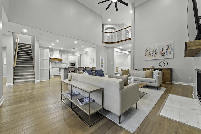 living room featuring ornamental molding, ceiling fan, and light hardwood / wood-style floors