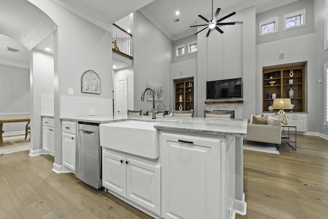 kitchen with sink, white cabinets, light stone counters, a towering ceiling, and ceiling fan