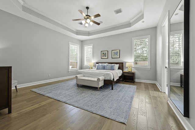 bedroom featuring a raised ceiling, ceiling fan, and crown molding