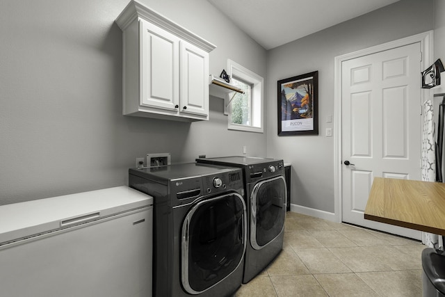 washroom featuring washer and dryer, cabinets, and light tile patterned floors