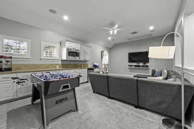 interior space with light colored carpet, ceiling fan, and vaulted ceiling