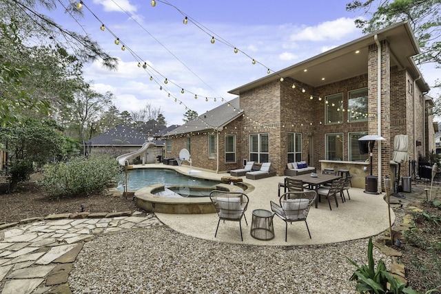 back of property with a pool with hot tub, cooling unit, and a patio area