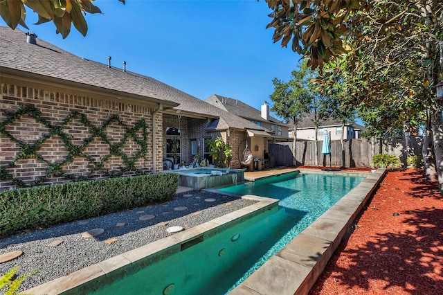 view of swimming pool with an in ground hot tub