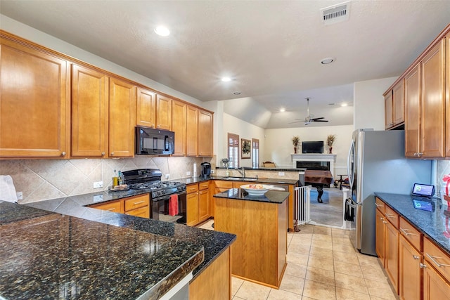 kitchen with kitchen peninsula, backsplash, sink, black appliances, and a kitchen island