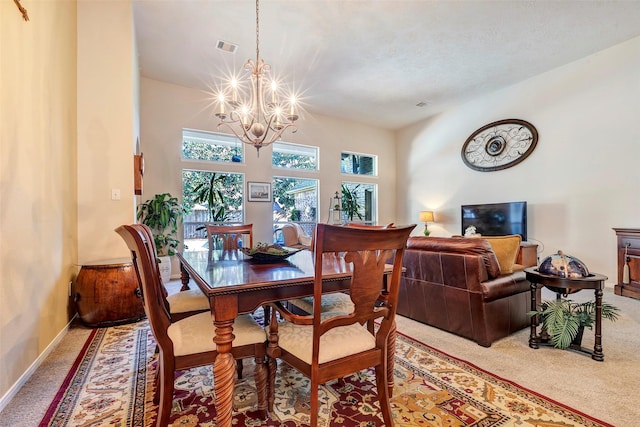 carpeted dining area with a chandelier and a textured ceiling