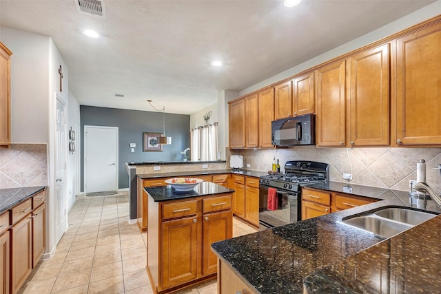 kitchen featuring pendant lighting, black appliances, sink, decorative backsplash, and kitchen peninsula