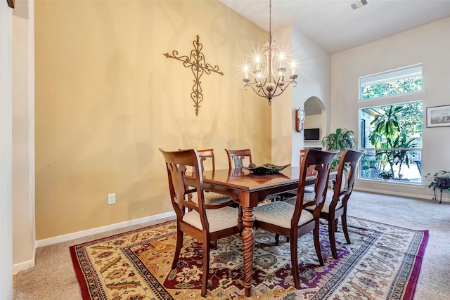 dining room featuring carpet flooring and a chandelier