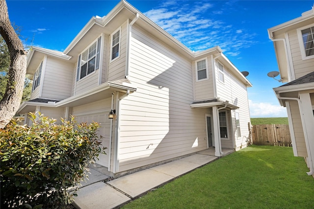 rear view of property featuring a garage and a yard