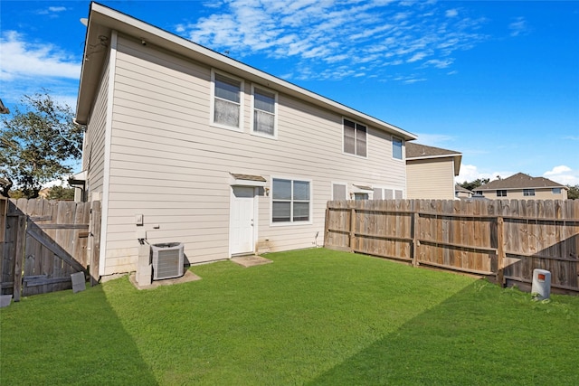 rear view of house featuring a lawn and central air condition unit