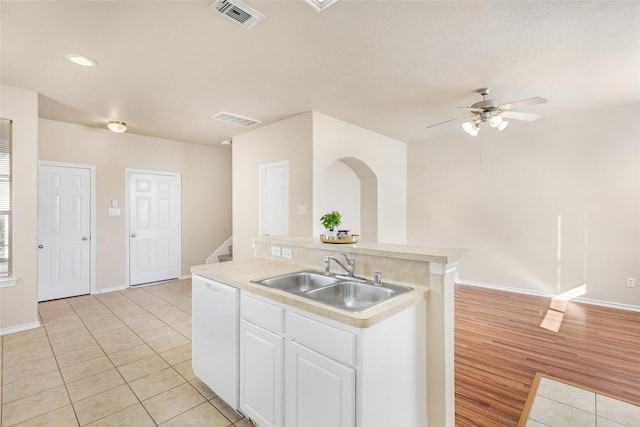 kitchen with sink, light tile patterned floors, ceiling fan, white cabinetry, and white dishwasher