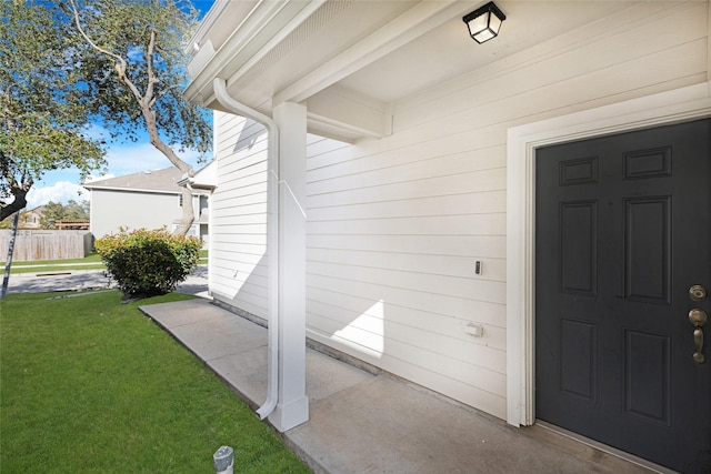 view of exterior entry with a yard