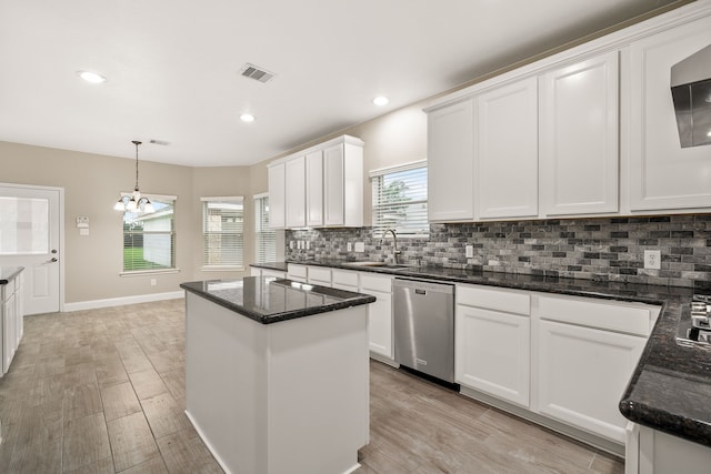 kitchen featuring stainless steel dishwasher, decorative light fixtures, white cabinets, light hardwood / wood-style floors, and plenty of natural light