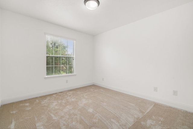 unfurnished room featuring light colored carpet