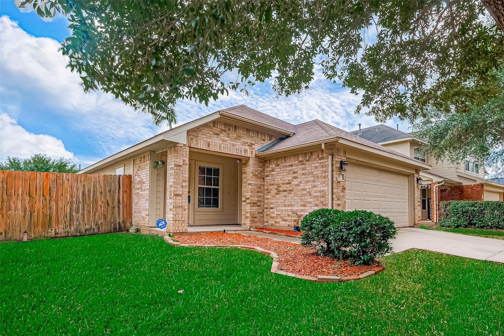 single story home featuring a garage and a front lawn