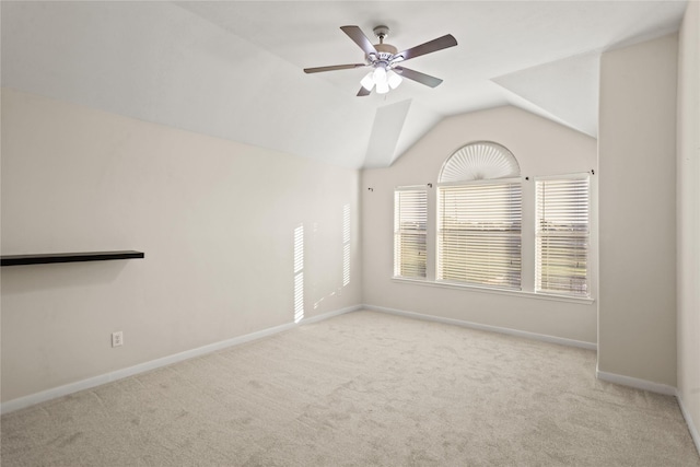 carpeted spare room with vaulted ceiling and ceiling fan