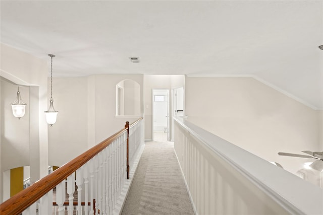 corridor featuring light carpet, lofted ceiling, and ornamental molding