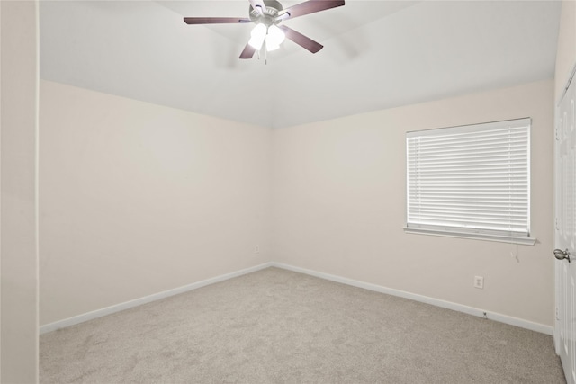 carpeted spare room featuring ceiling fan