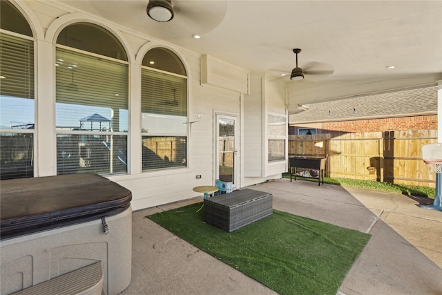 view of patio / terrace with ceiling fan and a covered hot tub