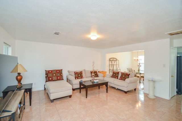 tiled living room with a textured ceiling and a notable chandelier