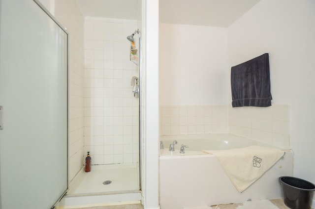 bathroom featuring shower with separate bathtub