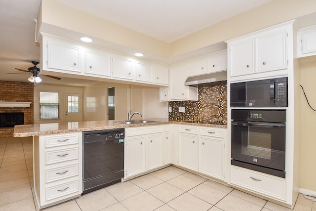 kitchen with a peninsula, under cabinet range hood, black appliances, white cabinetry, and a sink