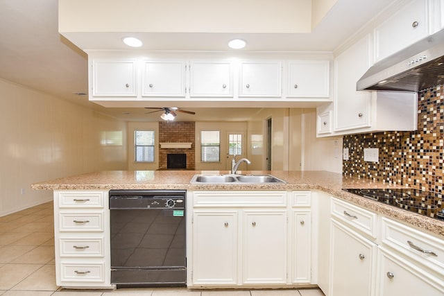 kitchen featuring a peninsula, ventilation hood, light countertops, black appliances, and a sink