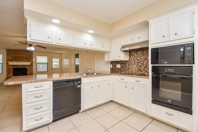 kitchen with under cabinet range hood, a peninsula, a sink, white cabinetry, and black appliances