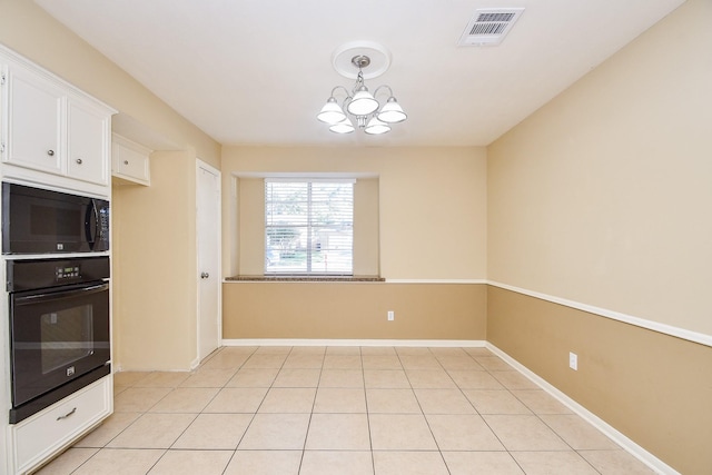 unfurnished dining area featuring visible vents, a notable chandelier, baseboards, and light tile patterned flooring