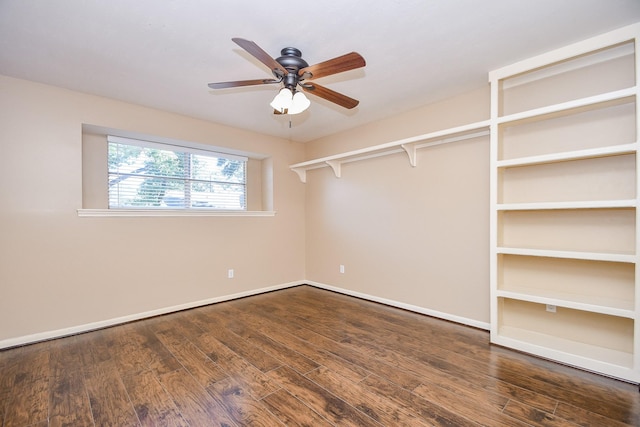 unfurnished room featuring a ceiling fan, dark wood-style flooring, and baseboards