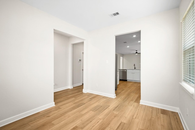 spare room with ceiling fan, sink, and light hardwood / wood-style floors