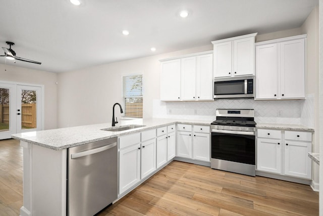 kitchen with appliances with stainless steel finishes, tasteful backsplash, white cabinetry, and sink