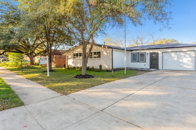 ranch-style house with a garage and a front lawn