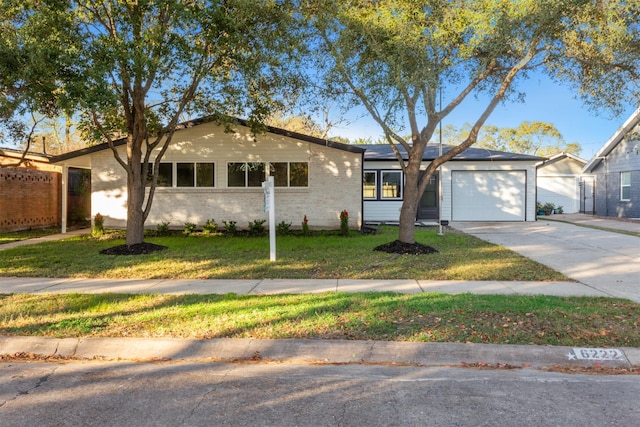 ranch-style home with a garage and a front lawn