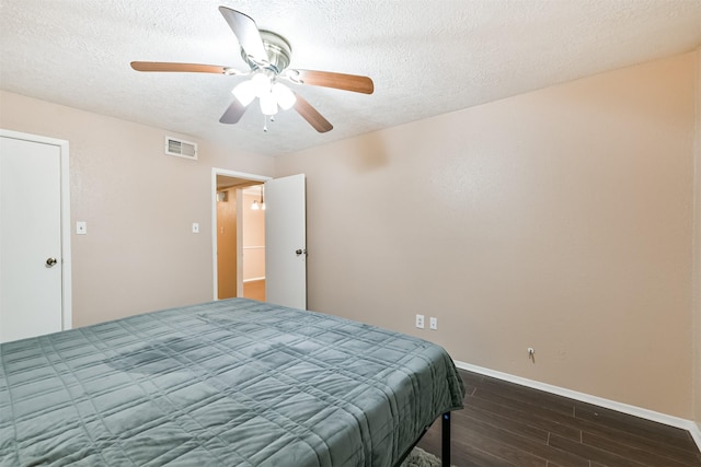 bedroom featuring a textured ceiling, ceiling fan, and dark hardwood / wood-style floors