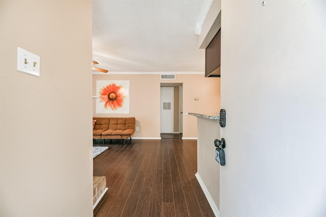 hall with dark wood-type flooring and crown molding