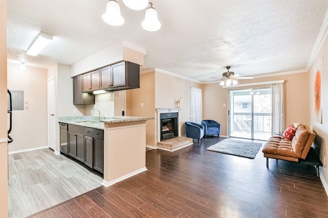 kitchen with a textured ceiling, ceiling fan, crown molding, and sink