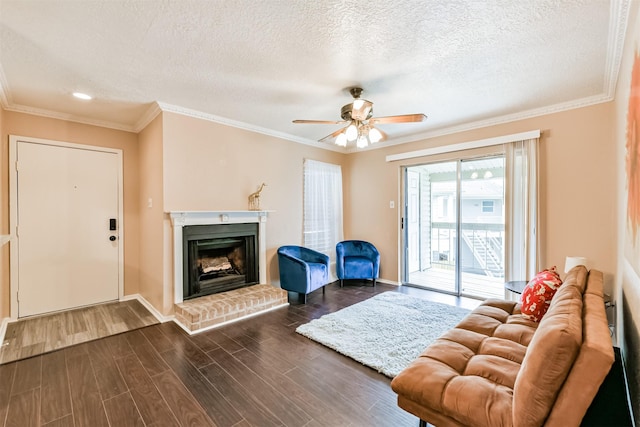 living room with dark hardwood / wood-style floors, ceiling fan, crown molding, and a textured ceiling